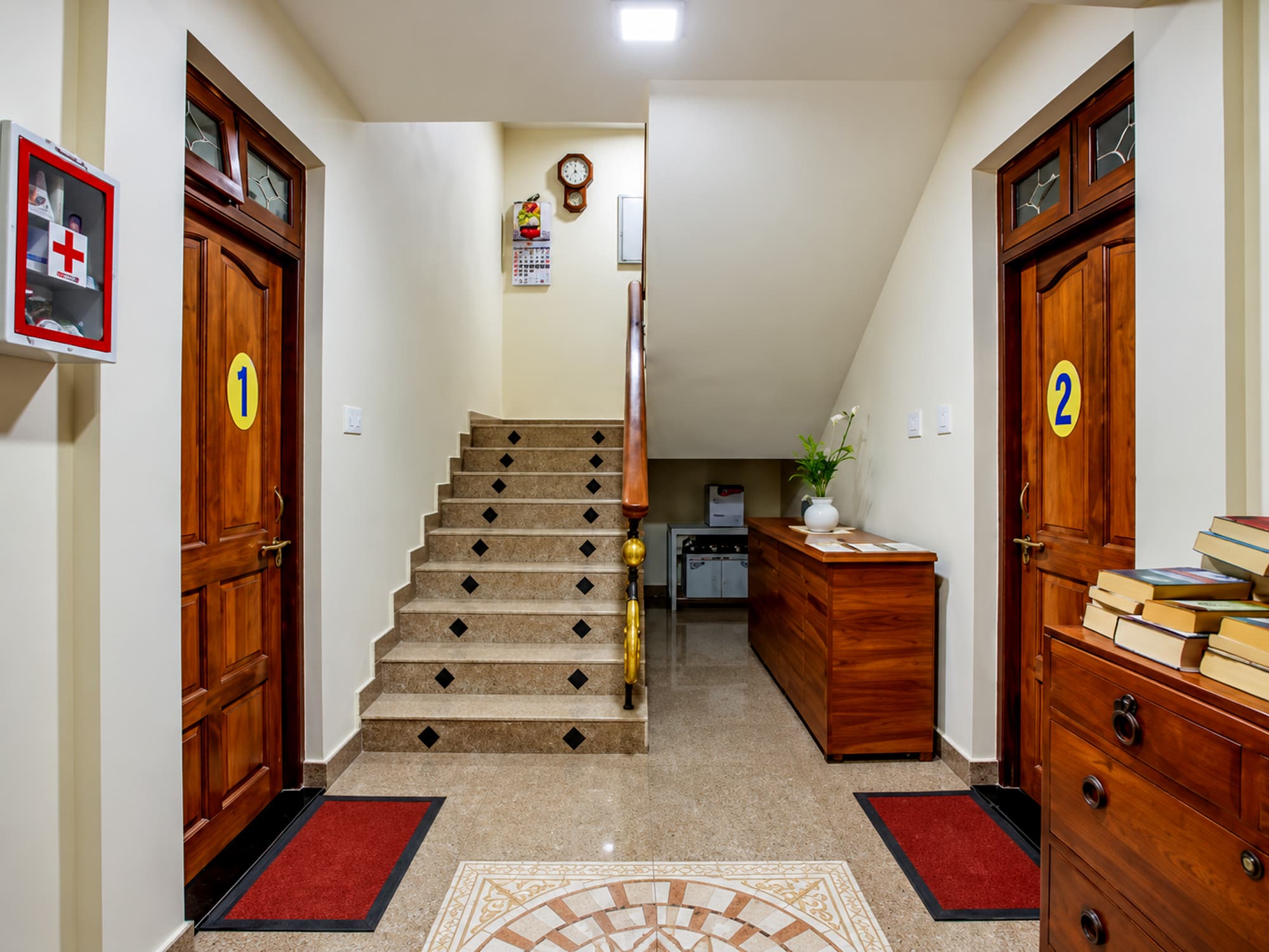 The studio landing at Misquita Comforts, with numbered doors and an inlaid marble floor.