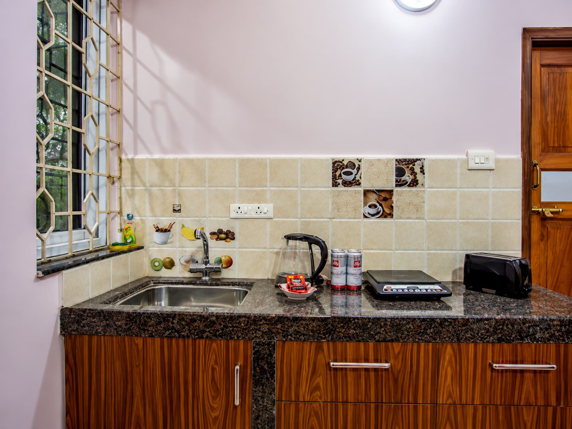 A studio pantry at Misquita Comforts with a granite counter, induction hob, kettle and toaster.