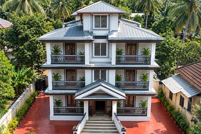 Elevated view of the Misquita Comforts building among the palms in Benaulim.