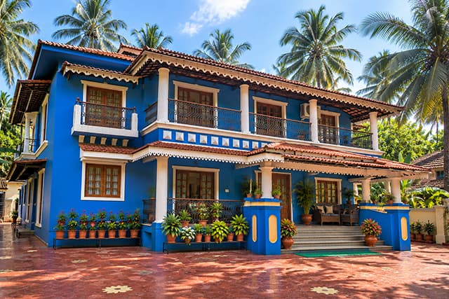 Side view of the blue Misquita Exclusive house among the palms.