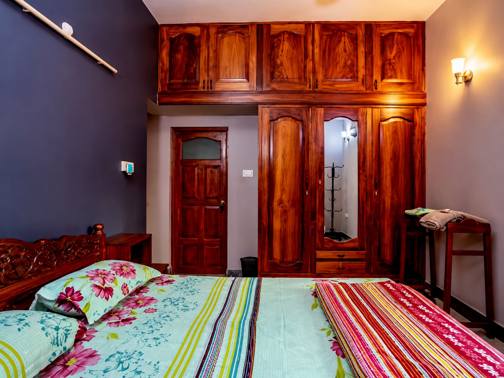 A bedroom at Misquita Exclusive with a carved wooden bed and fitted wardrobes.