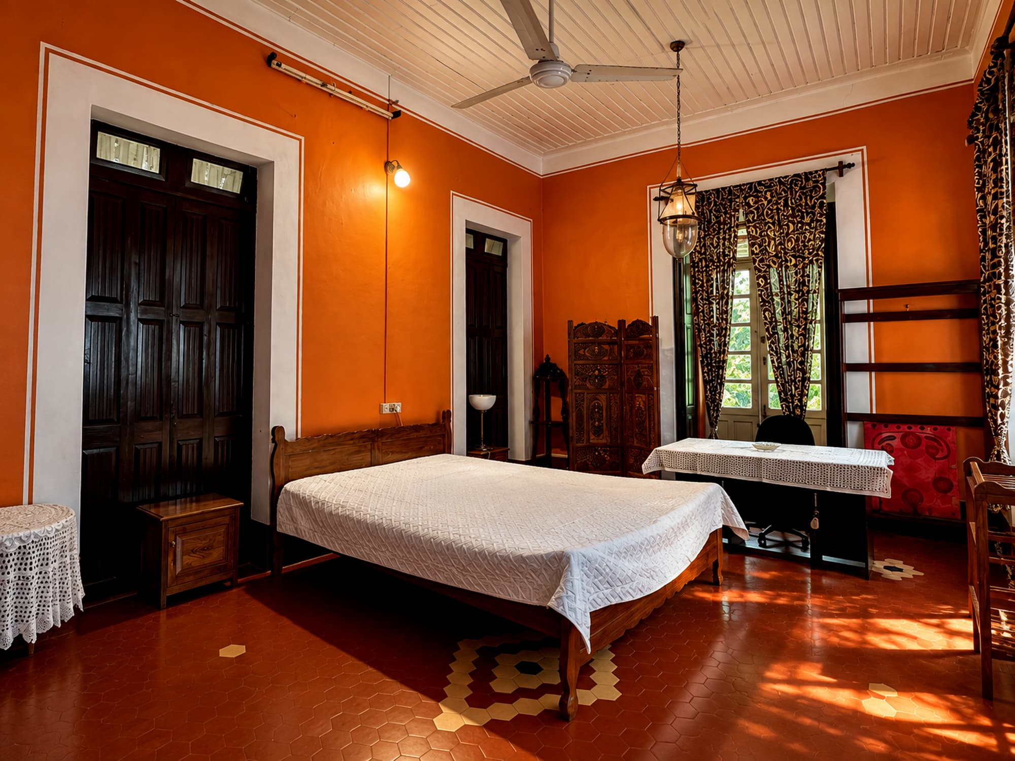 An air-conditioned bedroom with antique wooden furniture at Misquita Heritage.